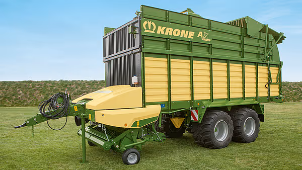 KRONE AX høstevogn med påmontet hakkemaskin, fotografert fra siden på åpen mark.