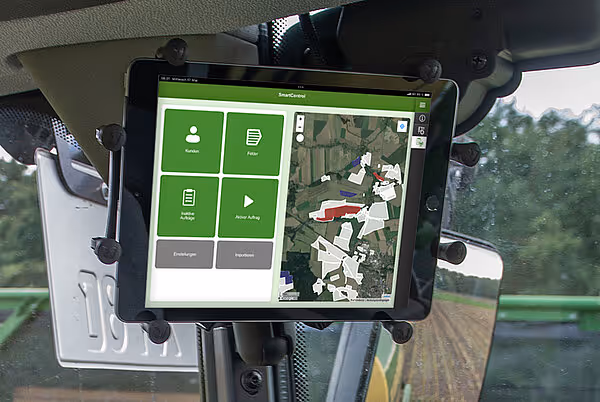 Tablet montert i førerhytten på KRONE maskin som viser SmartConnect grensesnitt med kart og kontrollpaneler.