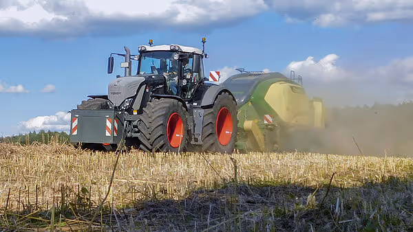 KRONE Big Pack Gen 5 storballpresse i drift på åker, trukket av grå traktor under pressing av halm på stubåker.