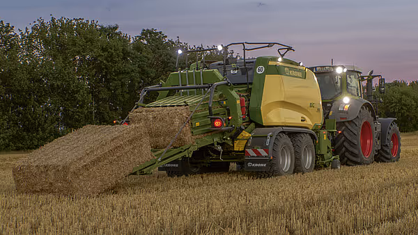 Krone BigPack storballepress i drift på kornstubber, med traktor som trekker maskinen mens den former rektangulære storballer.