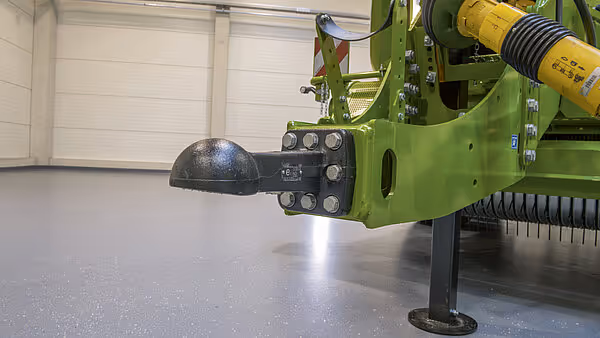 Trekkule med hydrauliske tilkoblinger på en grønn Krone rundballpress klar for tilkobling til traktor.