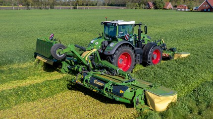 Grønn Fendt-traktor med Krone EasyCut B 1250 CV Fold Collect front- og bakmontert slåmaskin i arbeid på grønt gressjorde, fotografert fra drone.