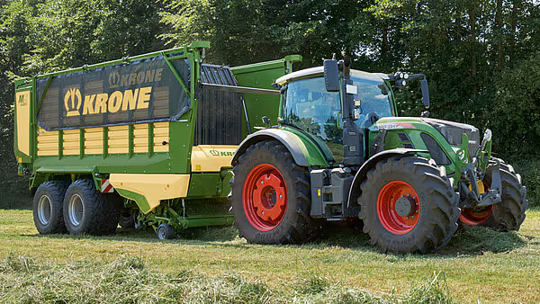 KRONE MX silofôrvogn med doblinger og grønt traktordekk på grøntarealet.