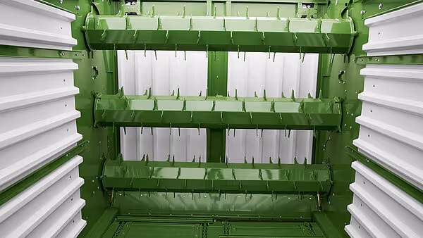 Innvendig oversikt over hauker og tabs i KRONE MX silofôrvogn, med hvite plastfletter montert på grønne barer for optimal fôrstrøm.