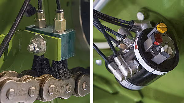 Smøringssystem på KRONE VariPack med automatisk smørepumpe og kjede til venstre, samt hydraulisk sylinder til høyre. Systemet sikrer vedlikehold av drivverket.