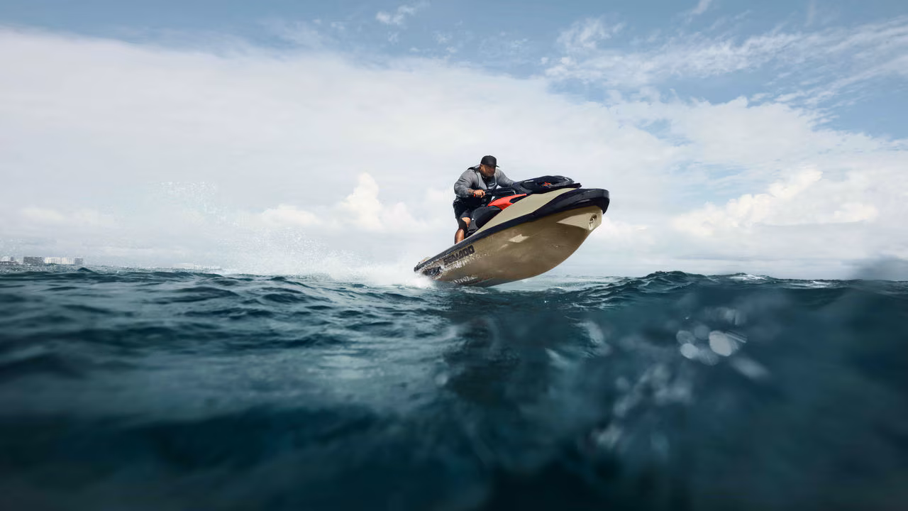 Mann som kjører en 2025 Sea-Doo RXP-X vannscooter og hopper i bølgene.