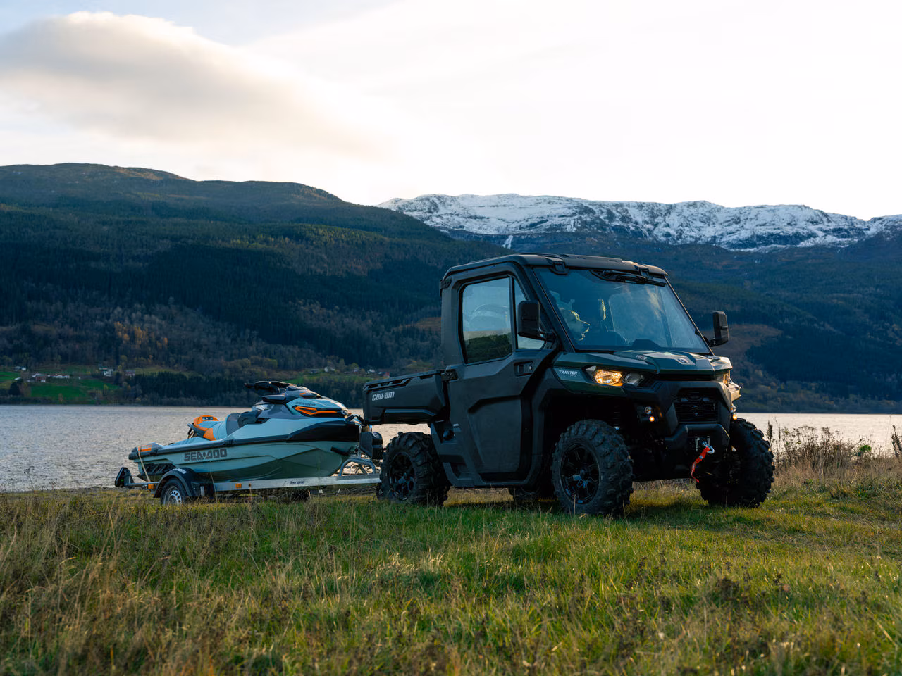Can-Am TRAXTER sleper en båt nær innsjøen.